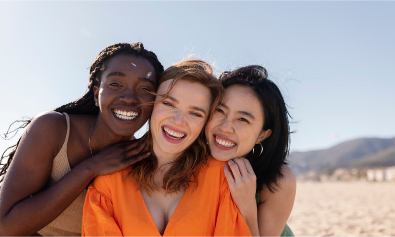 Three girls smiling on beach